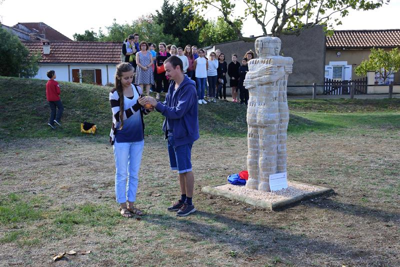 Deux jeunes volontaires internationaux (solidarités jeunesses) sont venus allumer et une bougie devant la culpture